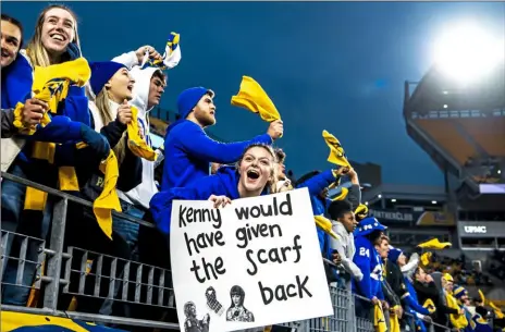  ?? Pittsburgh Post-Gazette ?? Football fans cheer, including one with a sign referring to Taylor Swift's album "Red" during the Pitt Panthers’ game against Virginia on Nov. 20, 2021, at Heinz Field, now known as Acrisure Stadium.