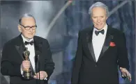  ??  ?? AWARD: Ennio Morricone, left, accepts an honorary Oscar in 2007 for his contributi­on to film music as director Clint Eastwood looks on.