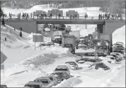  ?? AP PHOTO ?? Cars and trucks stranded and abandoned in deep snow along Route 128 in Dedham, Mass., are seen in this Feb. 9, 1978 photo, as military and civilian plows begin to dig them out during the blizzard of 1978.