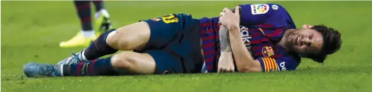  ?? — AP ?? Lionel Messi of Barcelona grimaces after a fall that broke his bone during the Spanish league match against Sevilla at the Camp Nou stadium in Barcelona on Saturday.