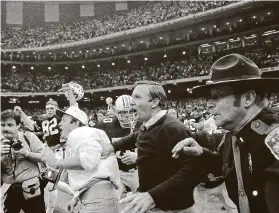  ?? Associated Press file ?? Coach Pat Dye, center, and the Auburn team rush the field after beating Michigan 9-7 in the Sugar Bowl on Jan. 1, 1984.