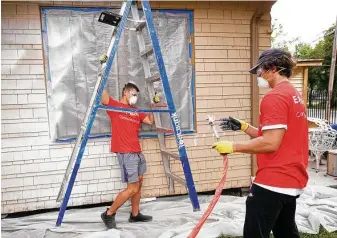  ?? Photos by Melissa Phillip / Staff photograph­er ?? Chance Koon, left, and Jack Barrick paint and make repairs to the 90-year-old Second Ward home of Maria Garza on Saturday. The volunteers worked with nonprofit Rebuilding Together Houston.