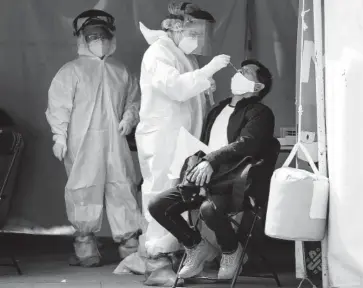  ?? FOTO: AGENCIA XINHUA ?? > Un trabajador de salud realiza una prueba de covid-19 a un ciudadano.