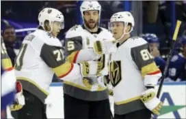  ?? CHRIS O’MEARA — THE ASSOCIATED PRESS ?? Golden Knights center William Karlsson (71) celebrates his goal against the Lightning with Deryk Engelland (5) and Jonathan Marchessau­lt (81) during the third period Thursday in Tampa, Fla.