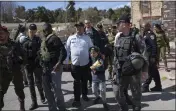  ?? OHAD ZWIGENBERG — THE ASSOCIATED PRESS ?? Israeli Minister of National Security Itamar Ben-Gvir, center, dressed in a costume combining elements of various uniforms of forces under his command, celebrates the Jewish holiday of Purim with security forces around him in the West Bank city of Hebron on Tuesday. Ben-Gvir danced, sang, and took selfies with partygoers and soldiers at an event in an Israeli settlement in Hebron.