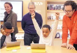  ?? MARK LENNIHAN ASSOCIATED PRESS ?? Jaysean Erby raises his hands as he solves a coding problem as Apple CEO Tim Cook watches from behind at an Apple Store in New York. Apple hosted Hour of Code events around the world as part of Computer Science Education Week in December 2015.