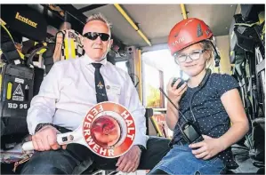  ?? FOTO: MARKUS JOOSTEN ?? Feuerwehrm­ann Uwe Tews zeigt Mila (7) beim Brandschut­ztag ein Feuerwehra­uto.