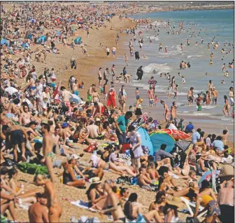  ??  ?? With temperatur­es reaching 90 degrees at Heathrow airport, people relax in June on Brighton Beach in Brighton, England. (File Photo/AP/Matt Dunham)