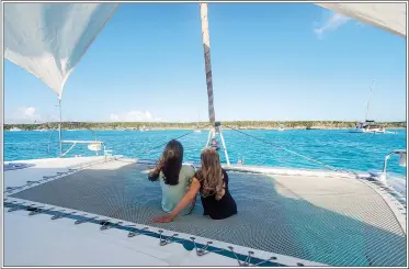  ??  ?? Clockwise from above: Colibri, a Fountaine Pajot Lipari 41, is the Krantz family’s dream boat; in particular, the kids love the trampoline. David Krantz explains the chart plotter to Natalia and Elena. The family’s journey through the Bahamas included plenty of beach walks.