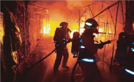  ??  ?? Firemen dousing the fire at the Jalan Masjid India bazaar. PIC COURTESY OF FIRE AND RESCUE DEPARTMENT