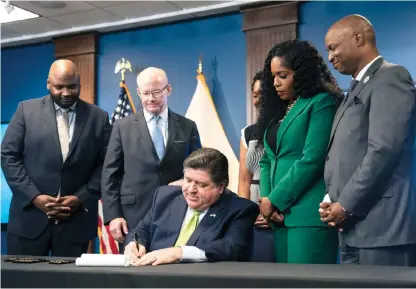  ?? PAT NABONG/SUN-TIMES ?? State Sen. Elgie Sims (from left), Senate President Don Harmon, Lt. Gov. Juliana Stratton, state Rep. Jehan Gordon-Booth and House Speaker Chris Welch watch Gov. J.B. Pritzker sign the 2025 budget on Wednesday.