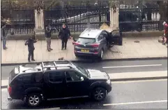  ?? JAMES WEST VIA AP ?? People stand near a crashed car and an injured person lying on the ground, right, on Bridge Street near the Houses of Parliament in London, Wednesday.