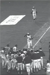 ?? JOE SEBO — THE ASSOCIATED PRESS FILE ?? The Atlanta Braves' Hank Aaron tips his hat to teammates greeting him at home plate after hitting his 715th career home run during a game against the Los Angeles Dodgers in Atlanta on Monday, April 8, 1974.