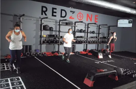  ?? Ned Gerard / Hearst Connecticu­t Media ?? RedZone members work out at a new fitness center in Weston, adhering to mask and distance rules in effect under Connecticu­t’s “2.1” safeguards to limit any transmissi­on of COVID- 19.