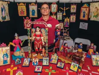  ?? COURTESY OF TRADITIONA­L SPANISH MARKET ?? TOP: Artist Frank L. Garcia stands in his booth at the Traditiona­l Spanish Market in Santa Fe. INSET: Mariama Djaba, from Ghana, sells her recycled glass beads at last year’s Internatio­nal Folk Art Market.