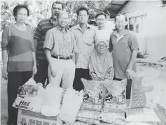  ??  ?? Lim (fourth left) with Saripah (seated), Salamah (right) and Jamaluddin (second left) after the presentati­on of the donated items at Kampung Haji Baki near Kuching.