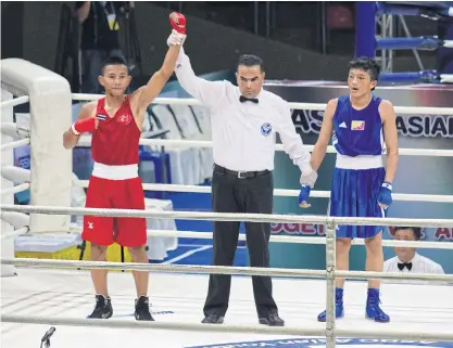  ??  ?? Thailand’s Noppharat Thakhui is declared the winner against Dechan Namgay of Bhutan.