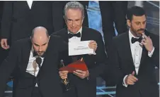  ??  ?? DECISION: Actor Warren Beatty shows the card reading Best Film
Moonlight next to La La Land producer Jordan Horowitz and host Jimmy Kimmel after the mistake at the Oscars.