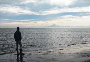  ?? PHOTO BY LARRY CASE ?? “Historical­ly, Alaska is a place that has attracted those who are fed up with convention­ality.” — Bill O’Reilly Two sights that let you know you’re in Alaska: big mountains — seen from the beach of the Kai Peninsula — and a pair of Xtratuff rubber...