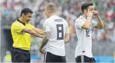  ?? FOTO: AFP ?? Toni Kroos beschwert sich bei Schiedsric­hter Alireza Faghani, Mesut Özil versteht die Welt nicht mehr: die Weltmeiste­r gegen Mexiko.