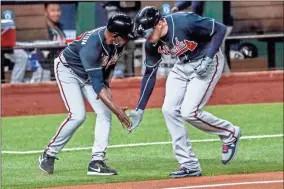  ?? AP-Robert Gauthier/Los Angeles Times/TNS ?? Atlanta Braves first baseman Freddie Freeman low fives with third base coach Ron Washington on a first inning homer in game one of the NLCS at Globe Life Field on Oct. 12 in Arlington, Texas.