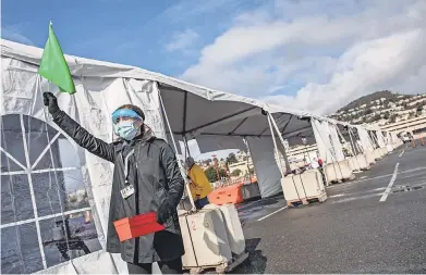  ?? MARTIN KLIMEK FOR USA TODAY ?? University of California- San Francisco employee Mary Hoffman uses a flag to request additional vaccine doses at a mass vaccinatio­n site at City College of San Francisco on Jan. 22.