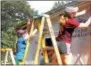  ??  ?? Volunteers install new siding on a home in need of repair for the Good Neighbors home repair project.