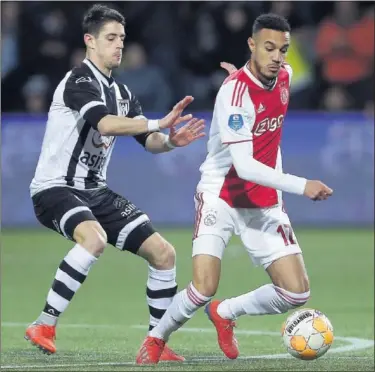 ??  ?? DEFENSA. Dalmau pelea un balón con Noussair Mazraoui, medio holandés-marroquí del Ajax.