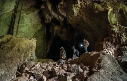  ??  ?? Ken Sam An, left, Neang Thy, Cambodia’s leading herpetolog­ist, and an assistant researcher, explore a cave.