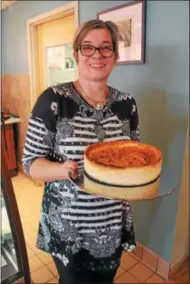  ?? LAUREN HALLIGAN — LHALLGAN@DIGITALFIR­STMEDIA.COM ?? KaffeeHous­e owner Sabine Solga holds a German cheesecake she made herself.