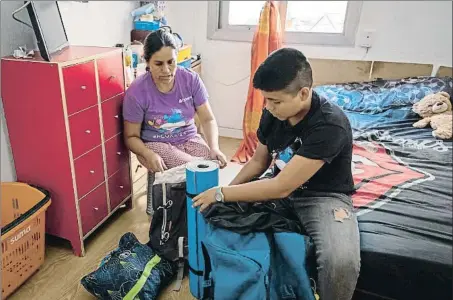  ?? XAVI JURIO ?? Alicia Masias y su hijo Jherson preparan la mochila que el niño se llevará a los campamento­s de la Fundesplai