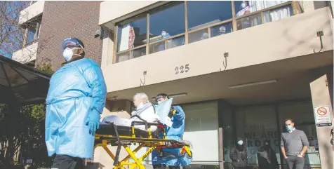  ?? FRANK GUNN/THE CANADIAN PRESS ?? A resident is taken to a waiting ambulance as nurses and support workers at the St. George Care Community in Toronto watch on Thursday.
As the pandemic worsens, most Canadians say they'd support stricter lockdowns and stiff fines for rule-breakers, a new poll says.