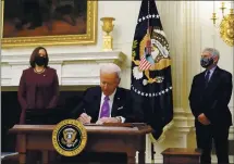  ?? ALEX BRANDON — THE ASSOCIATED PRESS ?? President Joe Biden signs executive orders dealing with the pandemic, accompanie­d by Vice President Kamala Harris and Dr. Anthony Fauci, director of the National Institute of Allergy and Infectious Diseases.