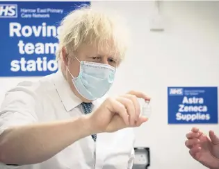  ?? PHOTO: REUTERS ?? Sharing required . . . British Prime Minister Boris Johnson sees how a dose of the Oxford/AstraZenec­a Covid19 vaccine is prepared for a mobile vaccinatio­n centre at Barnet FC’s ground at The Hive, in north London, last month.