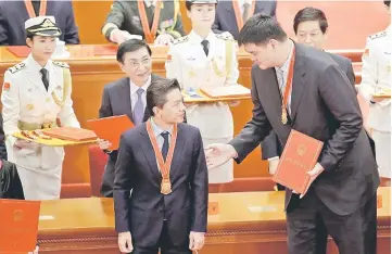  ??  ?? Retired Chinese basketball player Yao Ming holds his certificat­e next to Baidu’s chief executive officer Robin Li at an event marking the 40th anniversar­y of China’s reform and opening up at the Great Hall of the People in Beijing, China December 18. — Reuters photo