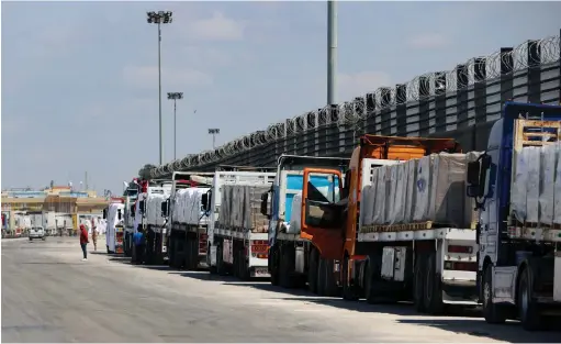  ?? (Mohamed Abd El Ghany/Reuters) ?? TRUCKS LINE UP near the Rafah border crossing on Saturday. It cannot be denied that the absence of an effective administra­tive mechanism to manage the distributi­on of humanitari­an aid is strongly felt, says the writer.
