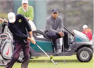  ?? ASSOCIATED PRESS FILE ?? In this file photo from June 13, 2012, Tiger Woods rests on a golf cart as Casey Martin takes a shot on the second hole of the U.S. Open at The Olympic Club in San Francisco.