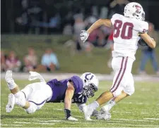  ?? [PHOTO BY BRYAN TERRY, THE OKLAHOMAN] ?? Tuttle’s Coby Trevino makes a long reception in front of Bethany’s David Miller during Friday’s game in Bethany.