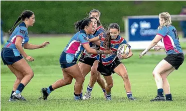  ?? WARWICK SMITH/ STUFF ?? Feilding Old Boys-o¯roua fullback Plum King, centre, tries to find a way through the Varsity defence at Massey University on Saturday.