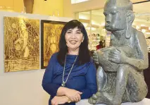  ??  ?? SM SVP for marketing communicat­ions group Millie Dizon beside Gilbert “Bergano” Alberto’s “The Rich Man’s Bulol” sculpture