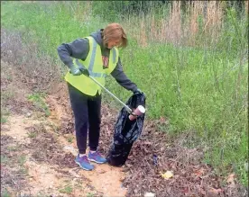  ?? Doug Walker ?? Floyd County Commission­er Allison Watters helps with a county employee litter pickup on Nichols Road on Friday.