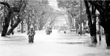  ??  ?? People go along flooded road after typhoon Damrey hits Vietnam in Hue city,Vietnam. — Reuters photo