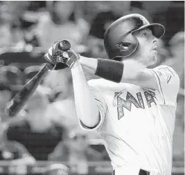  ?? WILFREDO LEE/AP ?? Marlins shortstop J.T. Riddle hits a triple against the Tampa Bay Rays on July 4 in Miami.