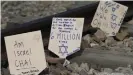  ??  ?? In normal years, marchers place handwritte­n plaques on the railroad tracks at the Auschwitz camp complex