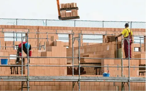  ?? Foto: Armin Weigel, dpa ?? Maurer arbeiten an einem Rohbau von Reihenhäus­ern. Mit dem Baukinderg­eld will der Staat Familien und Alleinerzi­ehende unterstütz­en.