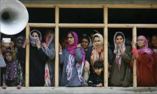  ?? MUKHTAR KHAN — THE ASSOCIATED PRESS ?? Kashmiri villagers watch from window of a house during the funeral of killed rebel commander Saddam Padder, in Heff village 65 kilometers (41 miles) south of Srinagar, Indian controlled Kashmir, Sunday. Government forces killed five rebels in fighting...