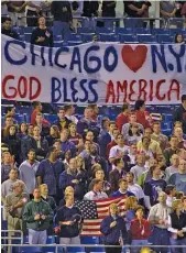  ?? GETTY IMAGES ?? Clockwise from left: The Cubs listen to the anthem before their game against the Reds on Sept. 18, 2001. Fans at Comiskey Park hold up a sign before the White Sox hosted the Yankees on Sept. 18, 2001. Members of the Sox participat­e in a moment of silence before a game against the Twins on Sept. 11, 2003.