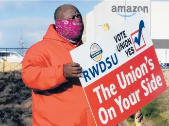  ?? JAY REEVES/AP ?? Michael Foster holds a sign outside an Amazon warehouse where labor is trying to organize workers in Bessemer, Alabama.