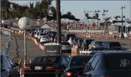  ?? RICHARD VOGEL — AP PHOTO ?? Los Angeles residents wait in line in their cars Tuesday to receive a covid-19vaccine at Dodger Stadium.