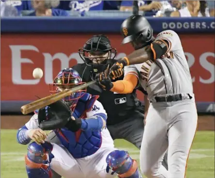  ?? MARK J. TERRILL — THE ASSOCIATED PRESS FILE ?? In this file photo, San Francisco Giants’ Andrew McCutchen hits a three-run home run as Los Angeles Dodgers catcher Yasmani Grandal and home plate umpire Stu Scheurwate­r watch during the eighth inning of a baseball game in Los Angeles.